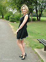 Hot Milf Monica posing in a gorgeous short black dress with matching shiny bumptious heels